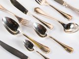a lot of silver spoons and forks on the table