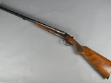 a rifle with a wooden handle on a white surface
