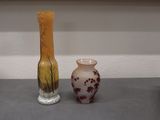 two vases that are sitting on a shelf next to each other