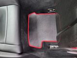 the interior of a car with red trims and a black floor mat