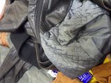 a pile of clothes and a jacket on a bed