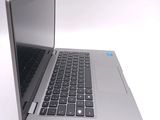 a silver laptop with a black keyboard on a white surface
