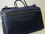 une image représentant un sac bleu posé sur une surface blanche