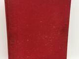 a red book sitting on top of a white surface