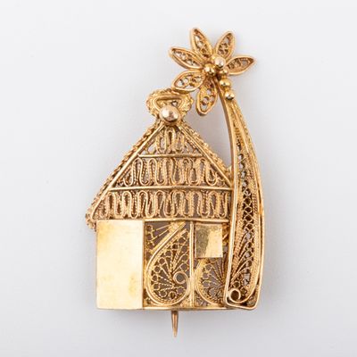 an image of a gold plated house brooch with a bird on top