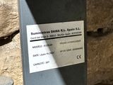 un parcmètre sur lequel est collé un autocollant, à côté d'un tas de pierres