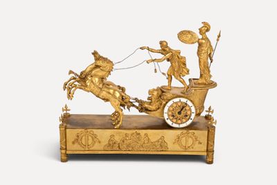 une figurine en or représentant une calèche tirée par des chevaux, avec un homme à bord
