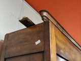 un gros plan sur un lit en bois devant un mur rouge