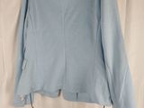 the back of a light blue blazer jacket hanging on a hanger