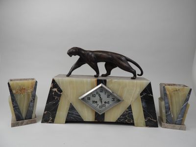 une horloge en marbre posée sur une table, surmontée d'un chat noir