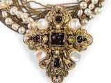a close up of a necklace on a white background with pearls