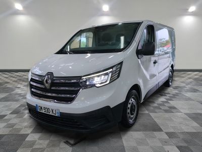 La camionnette blanche est garée dans une grande pièce au sol carrelé en damier.