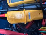 two multimeters and wires in a blue container