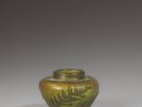 green glass vase on a white surface with a gray background