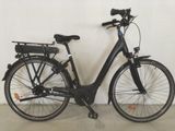 un vélo noir garé contre un mur dans une pièce