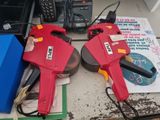 two red power tools sitting on top of a table