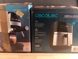 two boxes of coffee machines sitting on a table next to each other