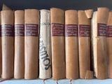 several old books are lined up on a shelf in a library