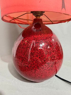 a red table lamp with a pink shade on it