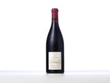 a bottle of red wine sitting on top of a white table