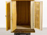 an old wooden cabinet with open doors on wheels in a room