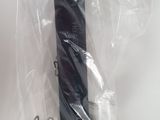 a black umbrella wrapped in plastic on a white surface