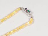 a yellow beaded necklace with a green, red, and blue bead