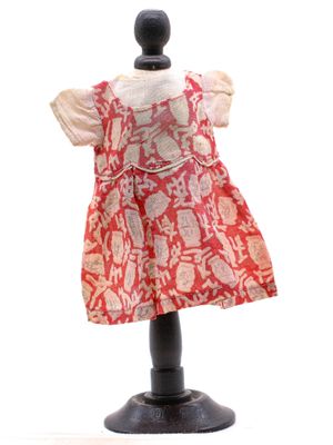 une photo d'une robe rouge et blanche posée sur un présentoir pour mannequin