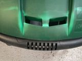 a close up of a green motorcycle with a black grill