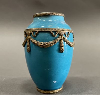 a blue vase with a gold decoration on it