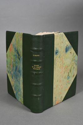 an old book with a green cover sitting on top of a table