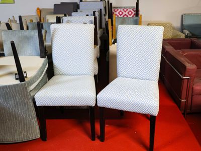 two chairs that are sitting next to each other in a room