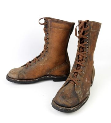une paire de bottes en cuir marron à lacets sur fond blanc