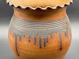 a brown and black vase sitting on a table