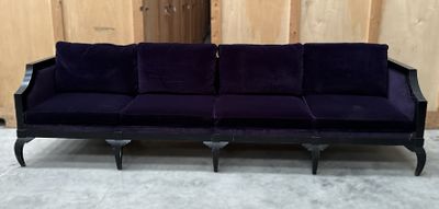 une image représentant un canapé violet posé sur un sol recouvert de moquette