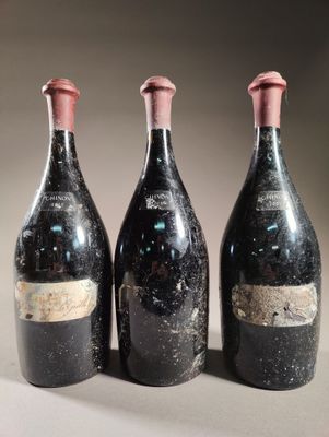 trois bouteilles de vin posées sur une table l'une à côté de l'autre