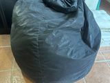 a black bean bag sitting on the floor next to a door