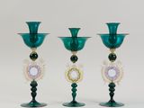three green glass vases sitting on top of a white table