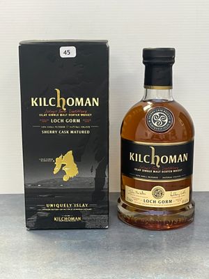 La bouteille de Kilchoman se trouve à côté d'une boîte d'alcools.