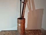 a cup with a pair of scissors and a rolling pin on a table