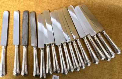 six couteaux en métal argenté sont alignés sur une table