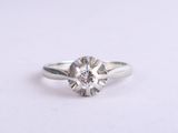 a close up of a diamond ring on a white surface
