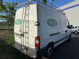 the back of a white van parked in a parking lot next to a building