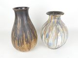 deux vases posés l'un à côté de l'autre sur une surface blanche