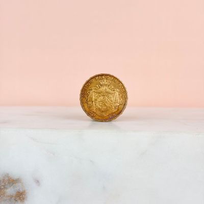 a gold coin sitting on top of a marble counter top