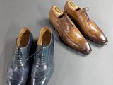 two pairs of men ' s shoes and a pair of shoes on a table