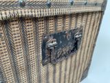 a close up of a woven suitcase with a metal handle