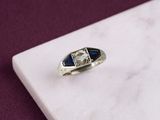 l'image d'une bague contenant une pierre bleue