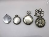 three silver pocket watches are sitting on a white surface