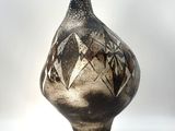 a black and white vase sitting on a white surface